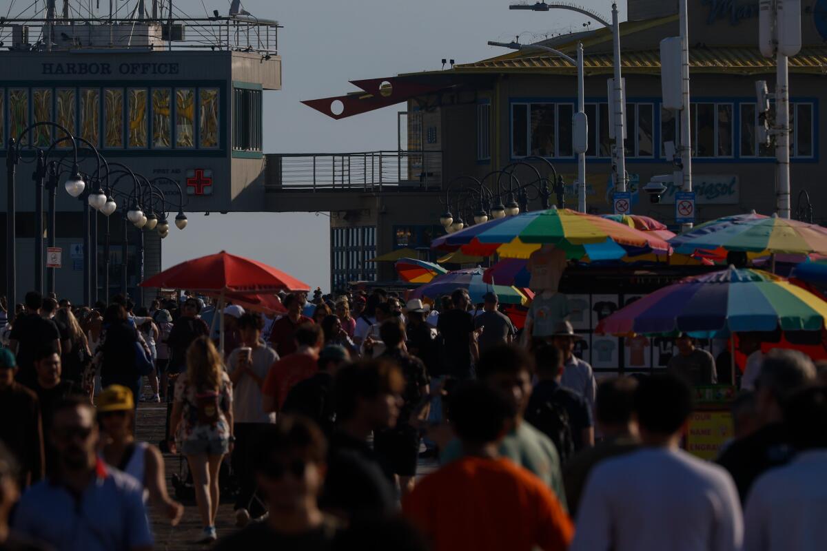 Tourists wander on the Santa Monica Pier. The waters beneath the pier made Heal the Bay's Beach Bummer List.