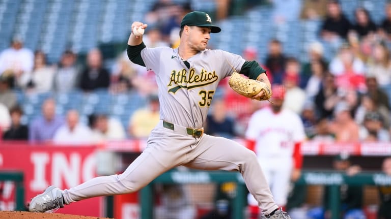 Athletics pitcher J.T. Ginn delivers during the first inning of...