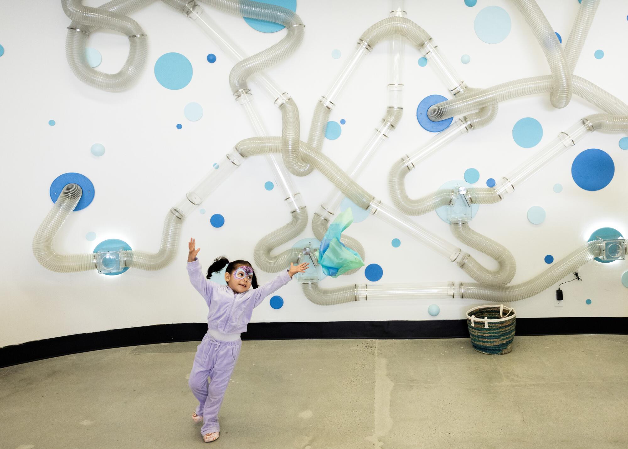 A young guest chases a cloth blown out of the tubes at the museum's Amazing Airways exhibit.