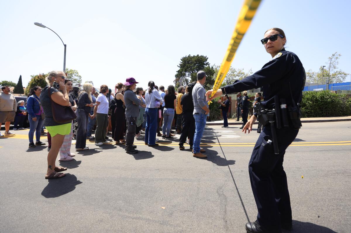 Parents of students at Kavod Charter School wait to be reunited after a shooting