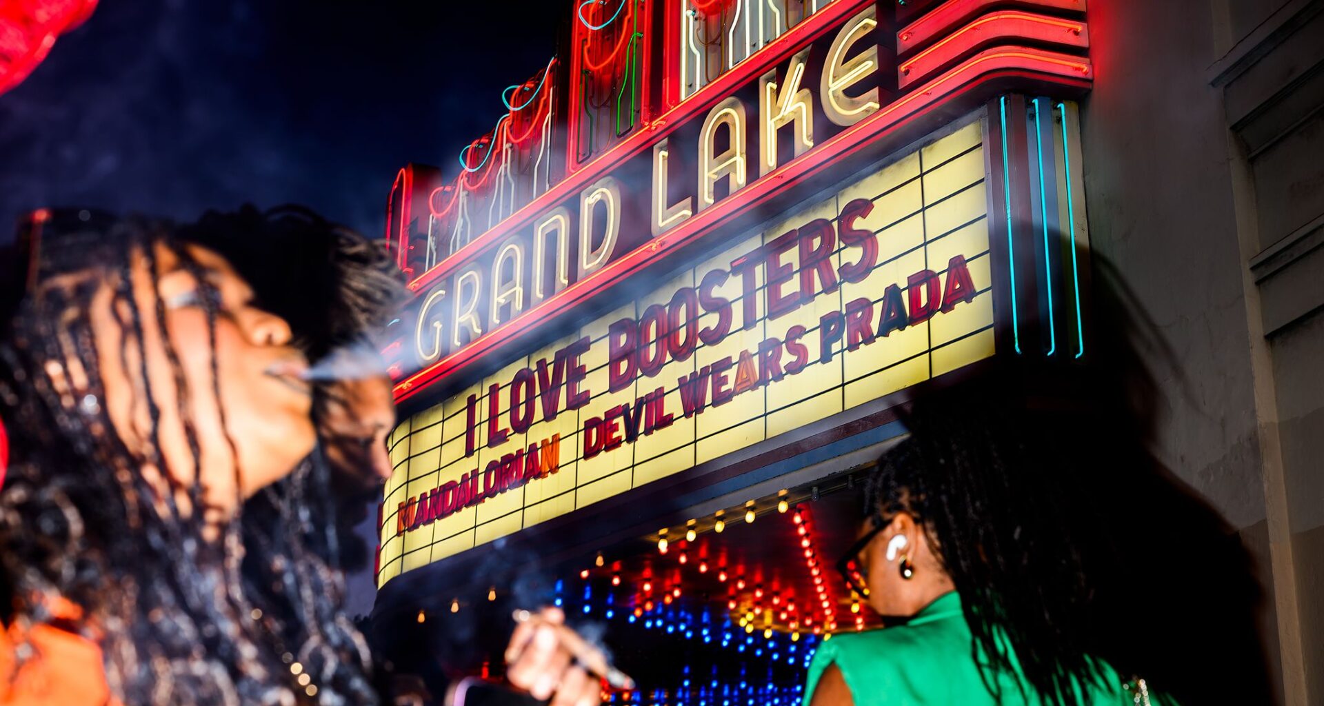 A woman smokes in front of the Grand Lake Theatre marquee before a showing of “I Love Boosters” at the Grand Lake Theatre in Oakland, Thursday, May 21, 2026.