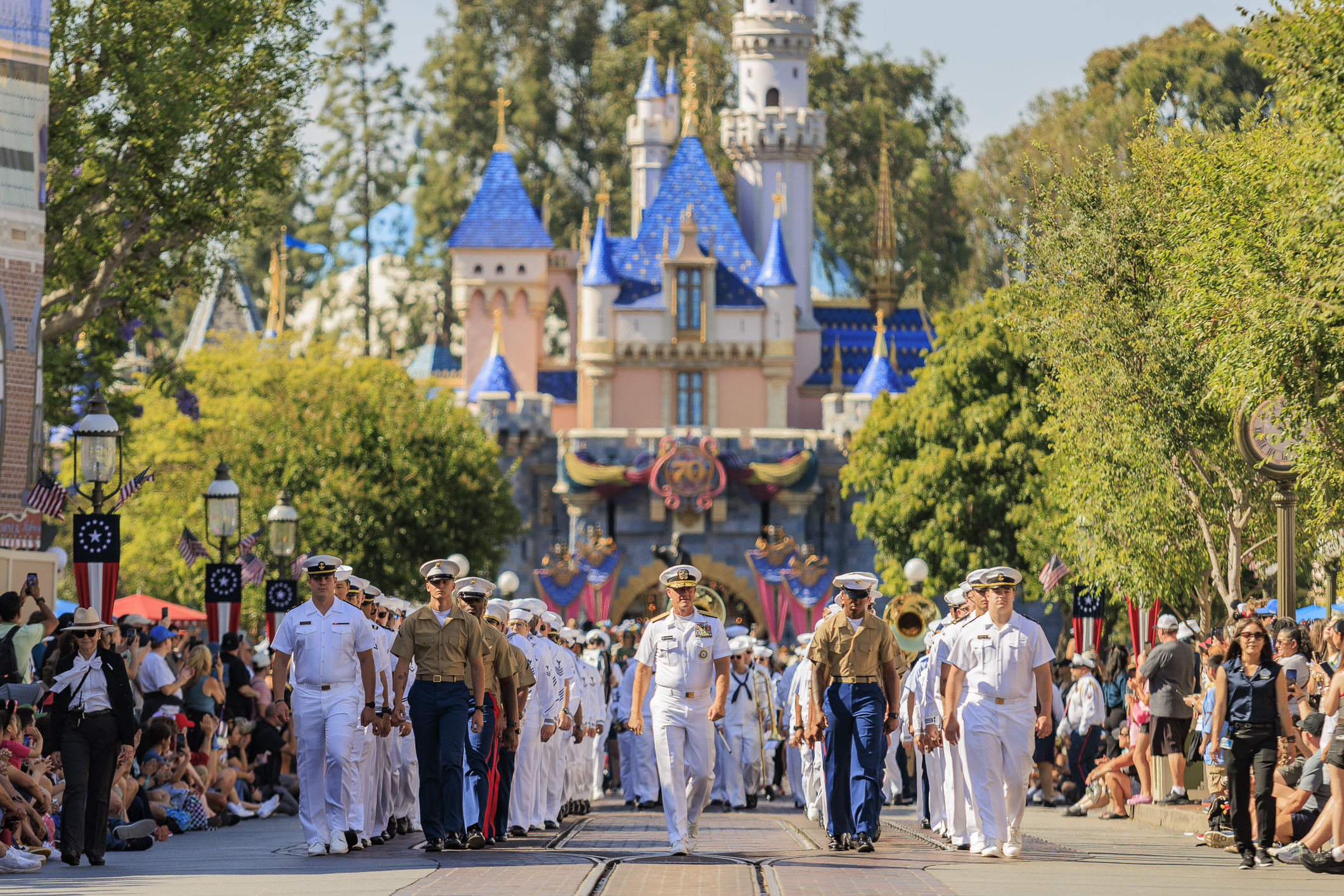 U.S. Sailors, Marines and Coast Guardsmen march down Main Street...