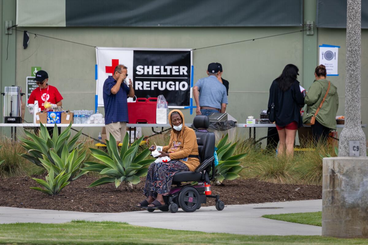 Evacuees take shelter as American Red Cross workers offer drinks and food at the Freedom Hall evacuation center