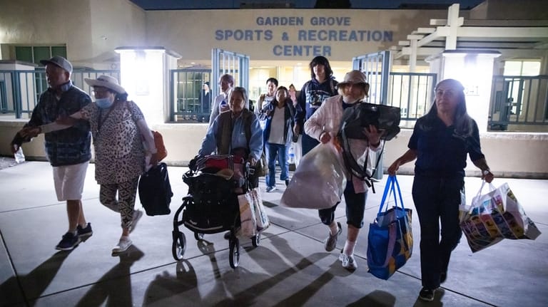 Evacuees from an aerospace chemical plant tank leak move to...