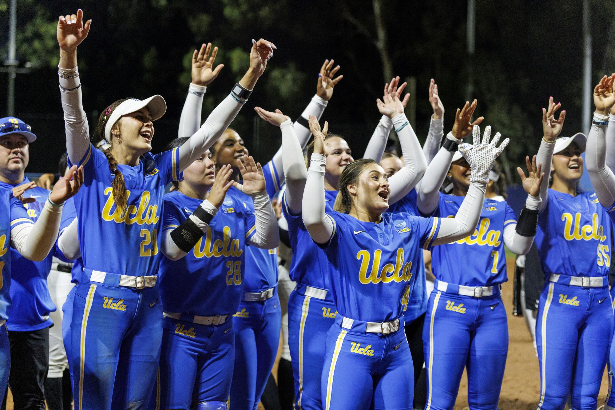 UCLA celebrate with fans after beating UCF 14-4 on Saturday to advance to the Women's College World Series.