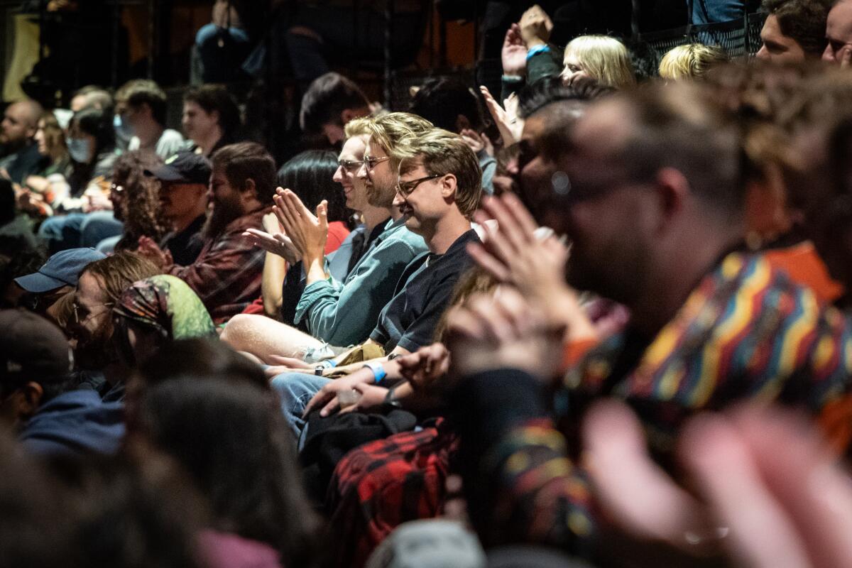 People clap while they attend the Democratic Socialists of America fundraiser.