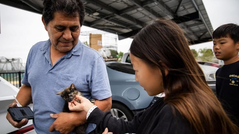 Oscar Bello, who evacuated Anaheim with his pets, shows them...