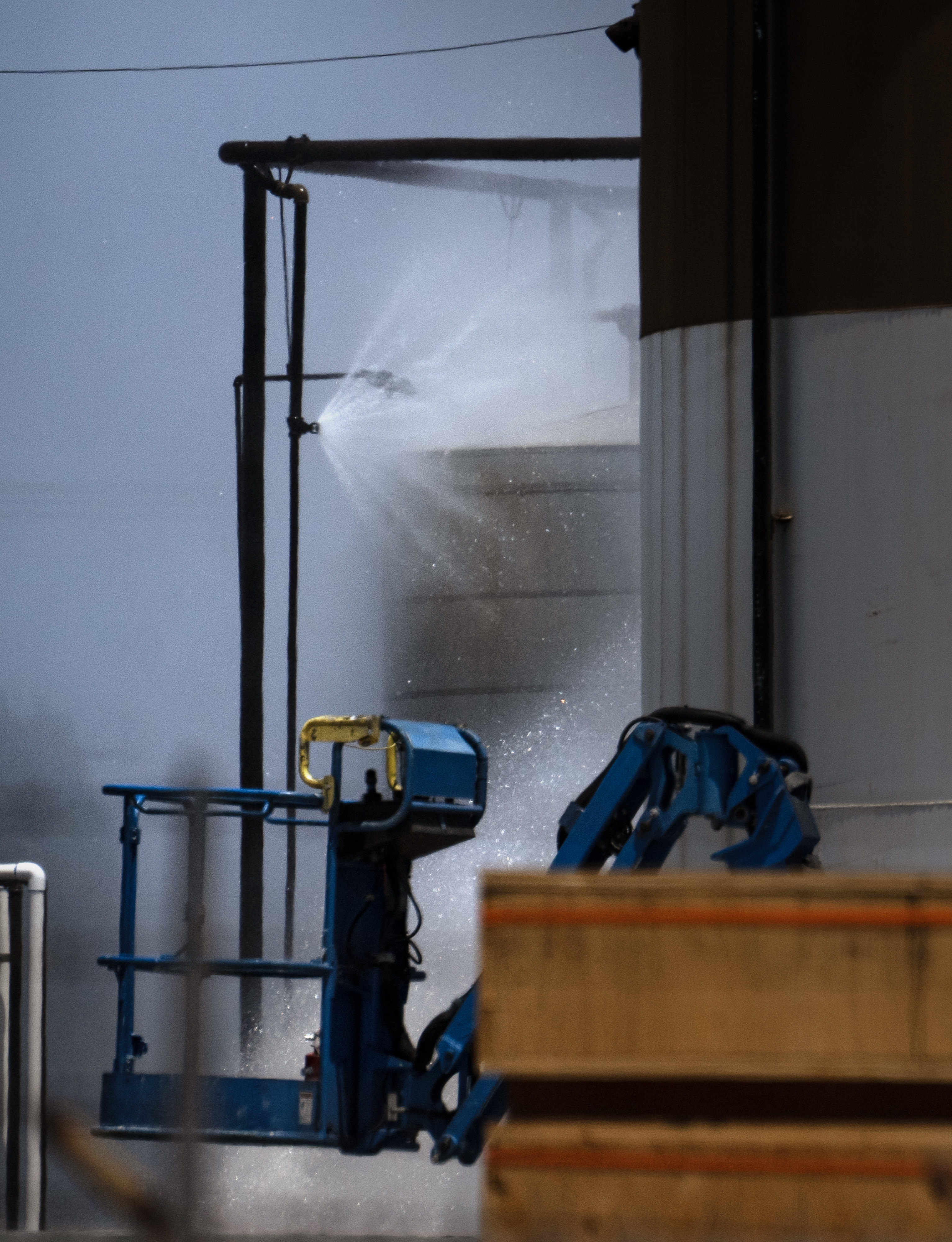 Water continues to spray on an overheated 34,000-gallon tank at...