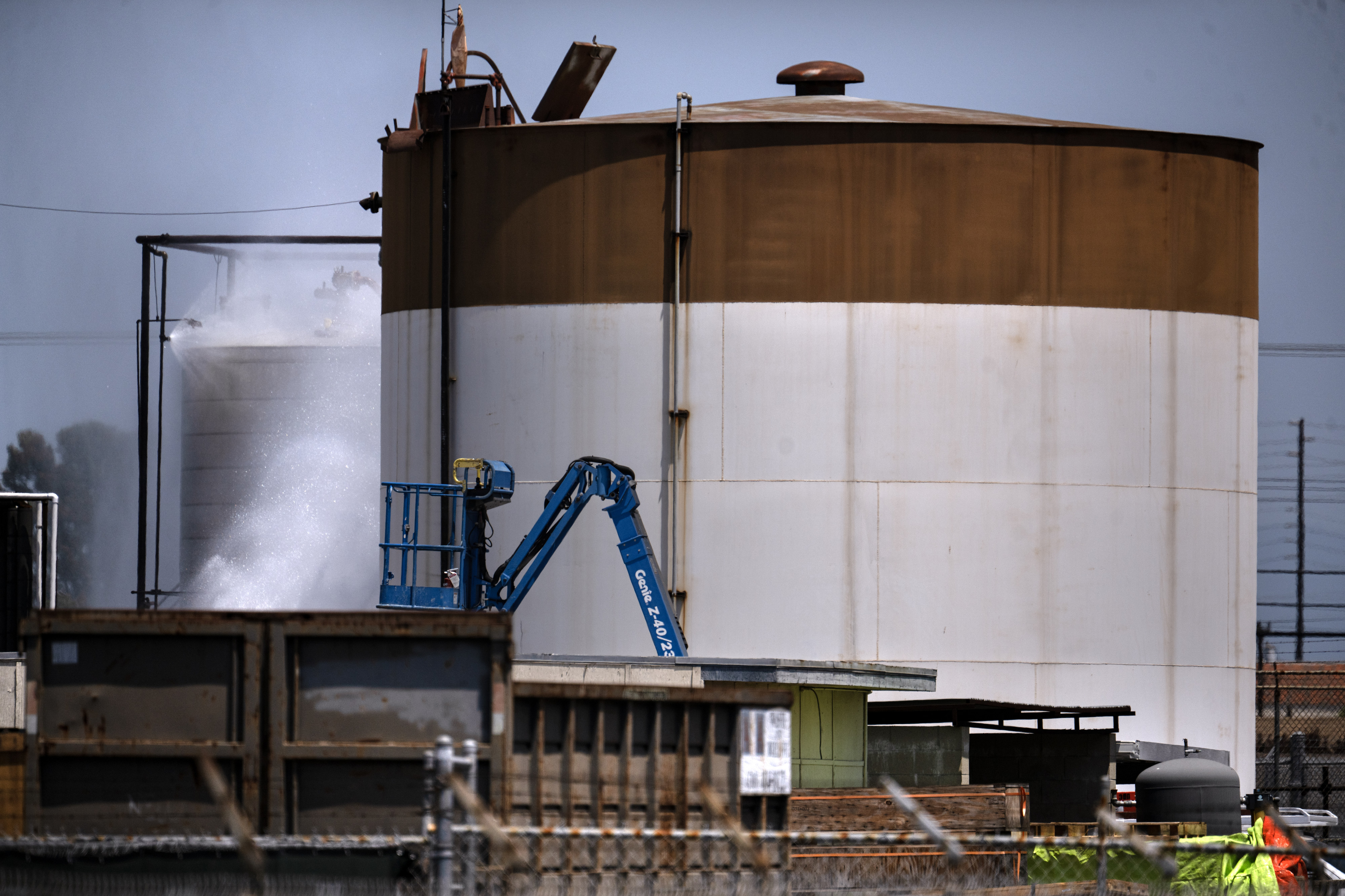Water continues to spray on an overheated 34,000-gallon tank at...