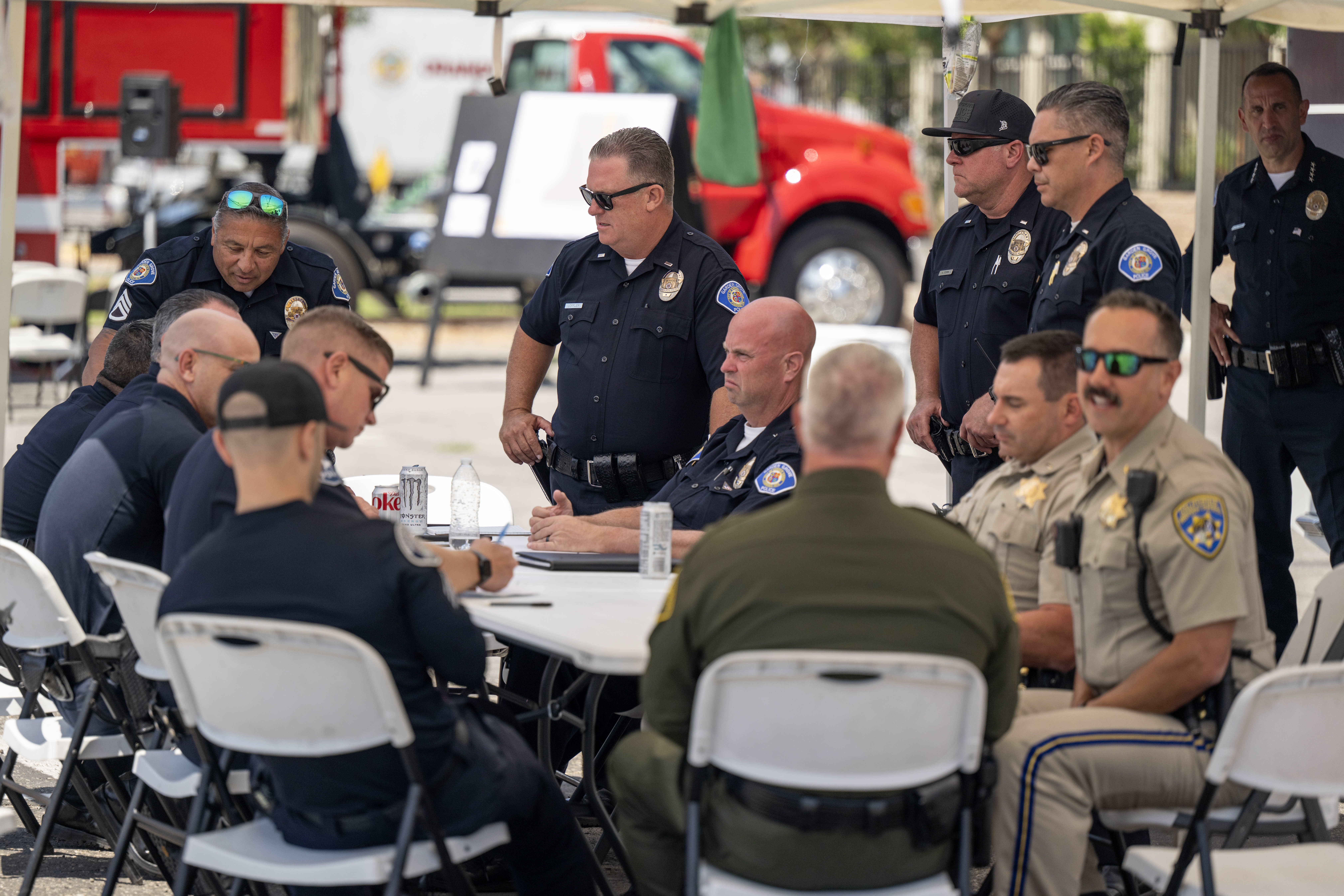 Garden Grove police officers meet under a tent outside their...