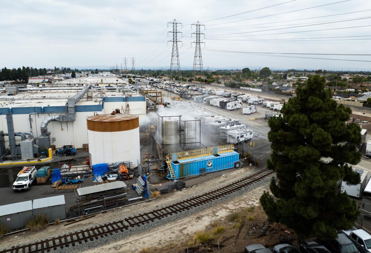 An aerial of water being sprayed on large storage tanks at the GKN Aerospace facility on Sunday in Garden Grove.