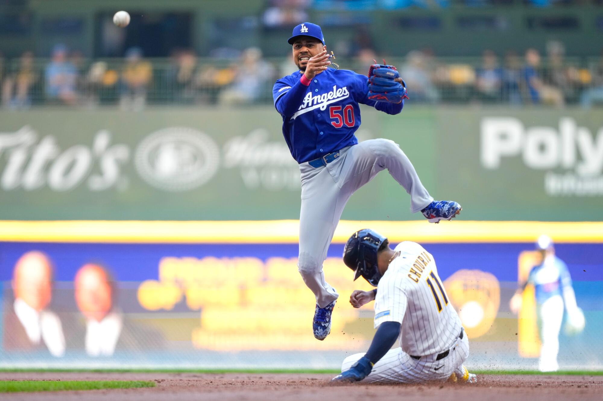 Dodgers shortstop Mookie Betts turns a double play during a win Sunday in Milwaukee.