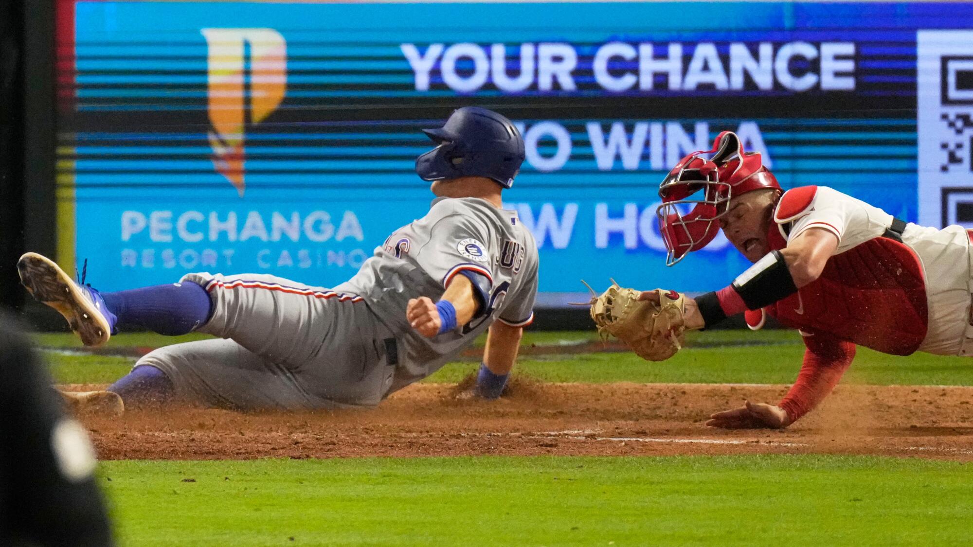 The Rangers' Josh Jung is tagged out at home by Angels catcher Logan O'Hoppe on Friday at Angel Stadium.