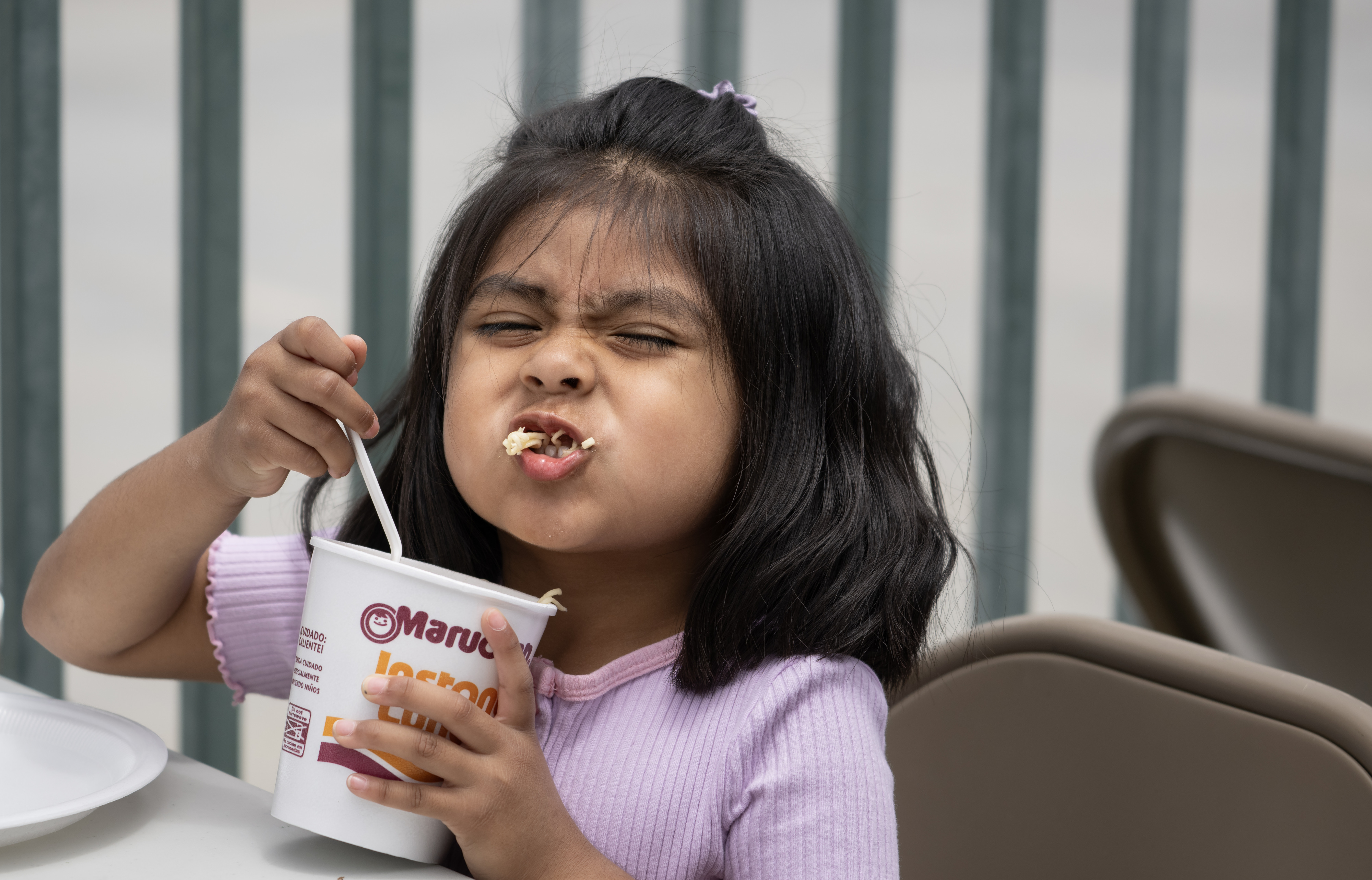 Four-year-old Ruby Arcos slurps a cup of noodles at Golden...