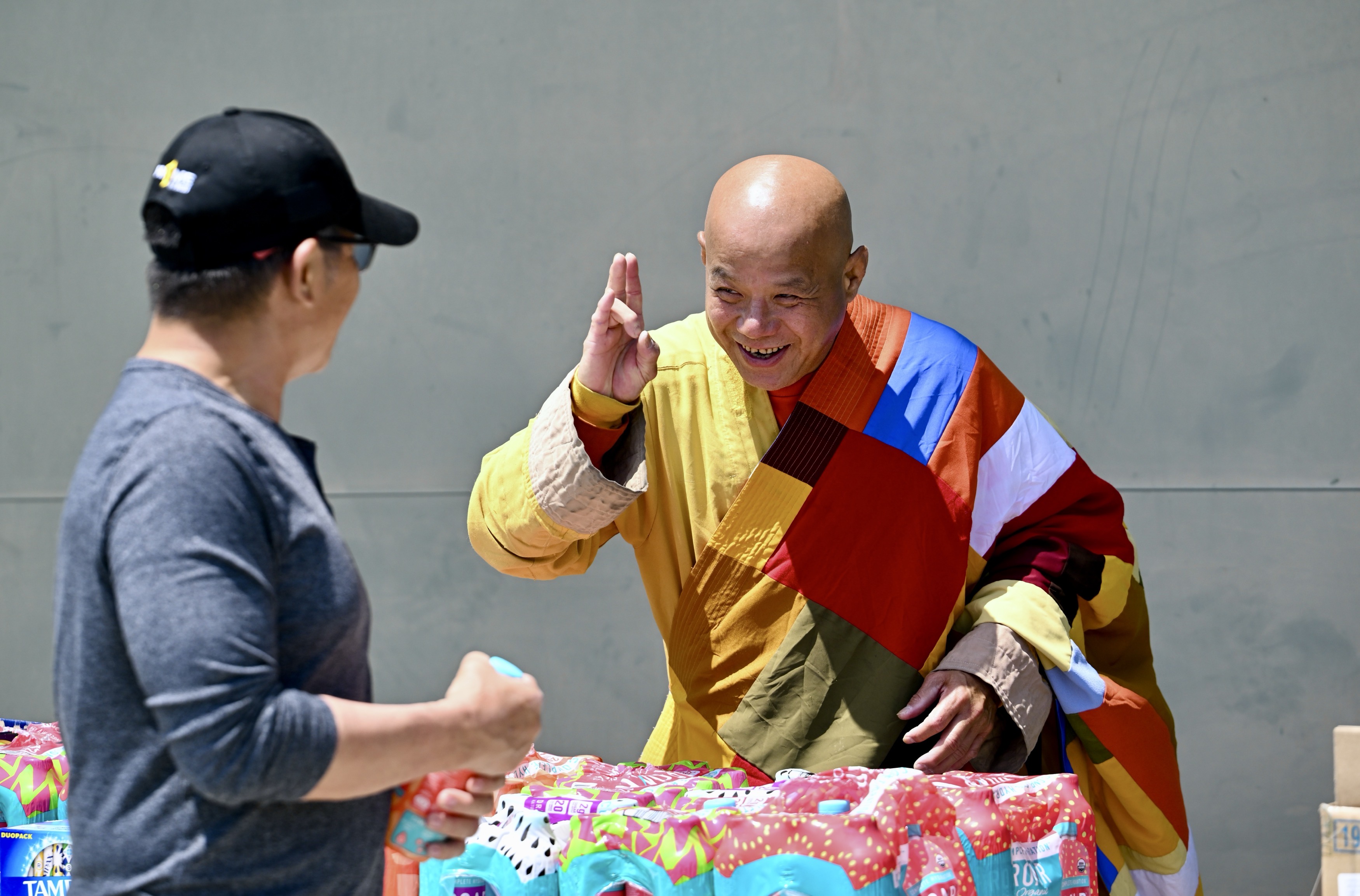 Monk Lincoln Long greets an evacuee as he hands out...