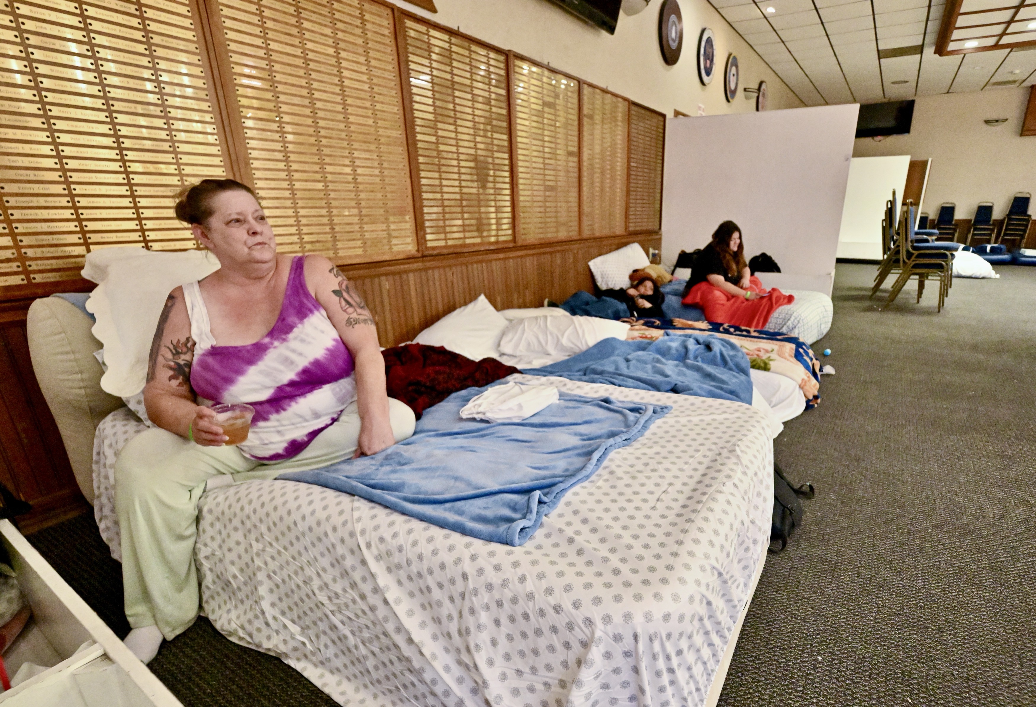 Evacuee Kimberly Casares sits on a cot with her family...