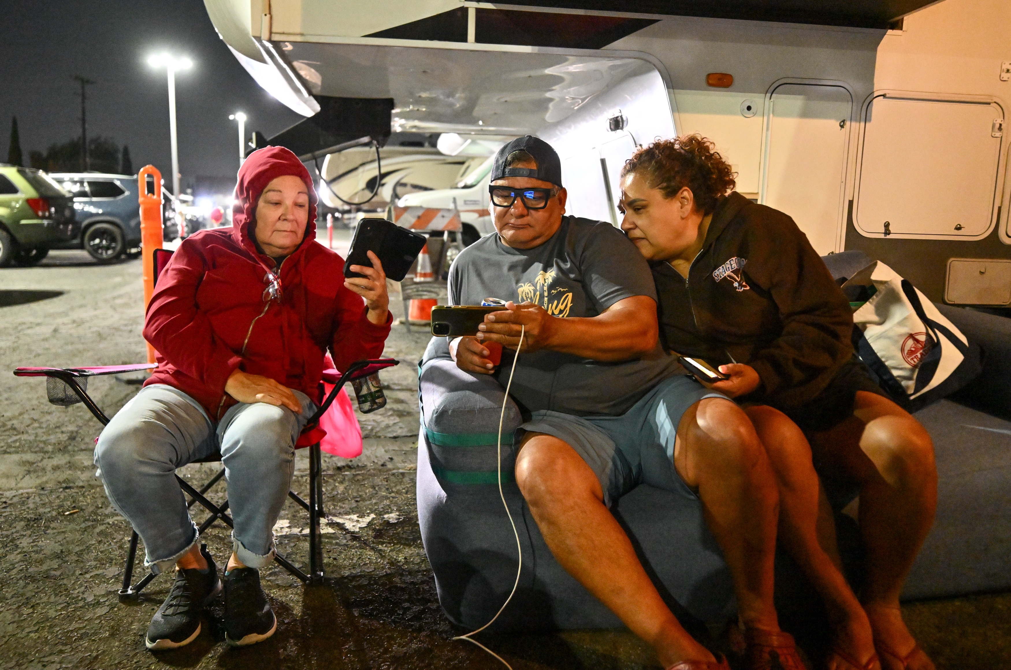 Evacuee Julian Cesneros, center, sits with his wife, Rosemary Cesneros,...