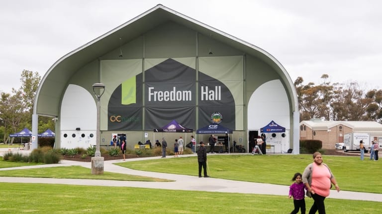 People walk outside Freedom Hall, an evacuation center in Fountain...