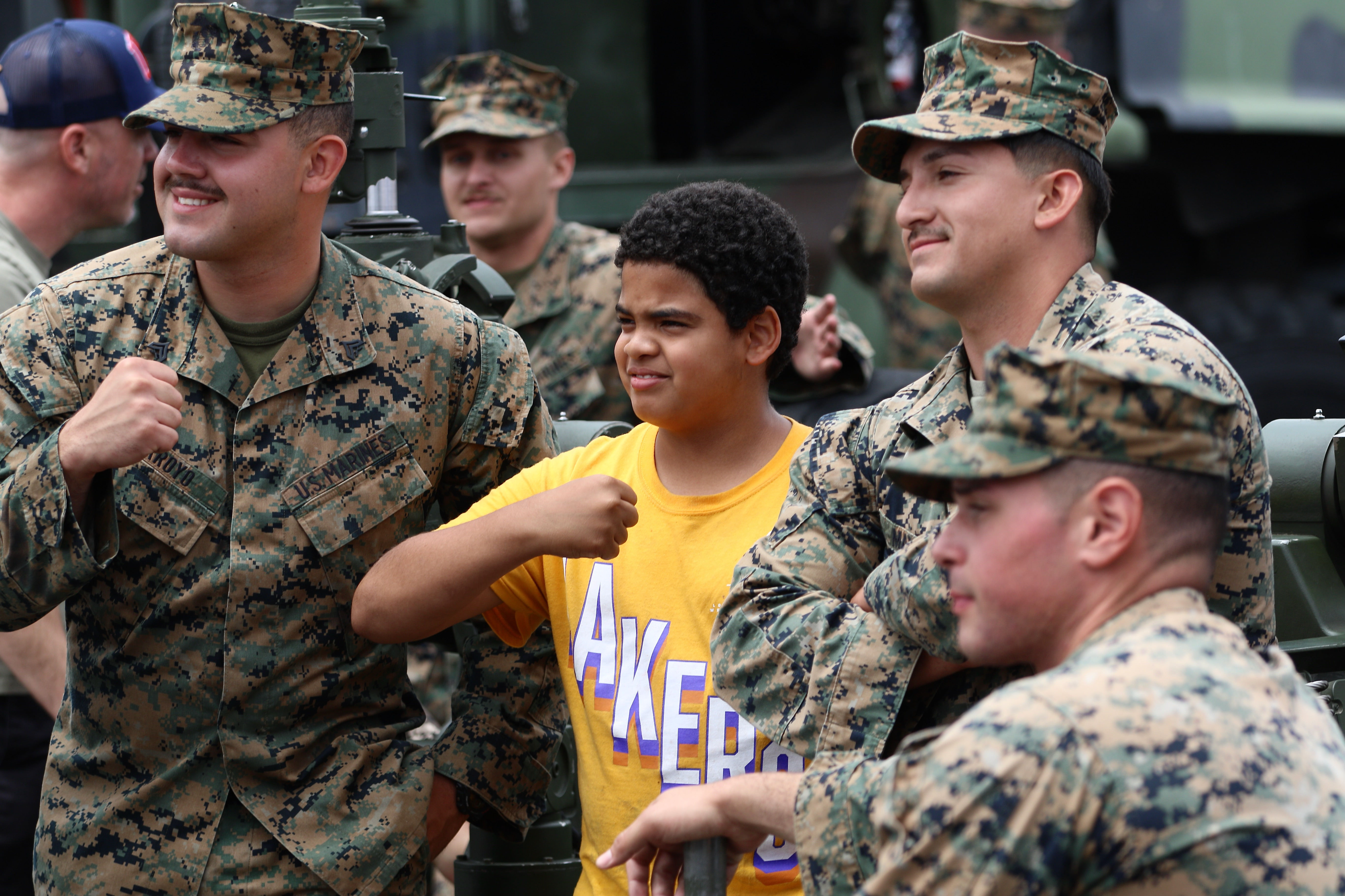 Norman Bracamonte of Los Angeles, 11, flexes with Marines from...