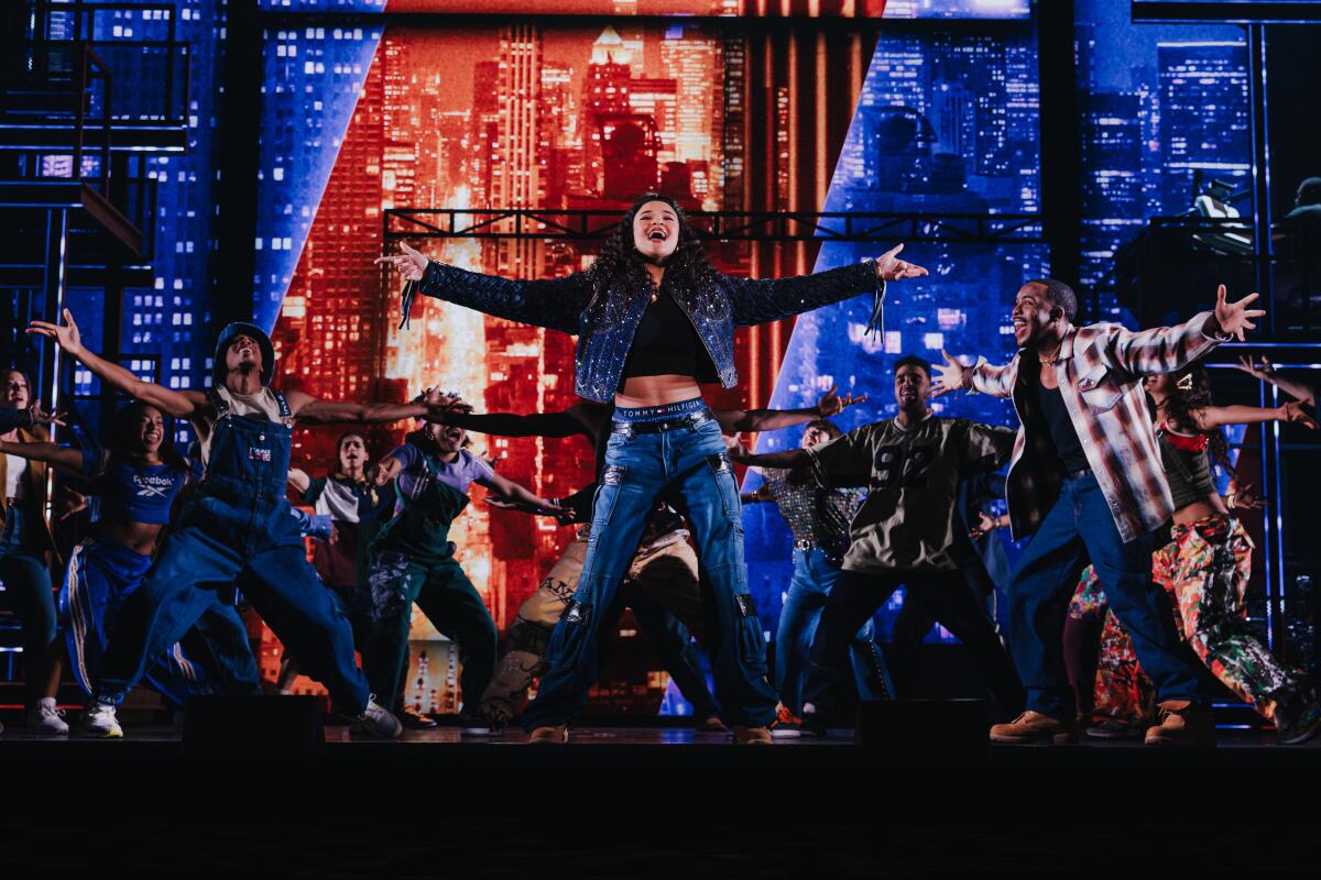 A woman sings onstage in a musical.