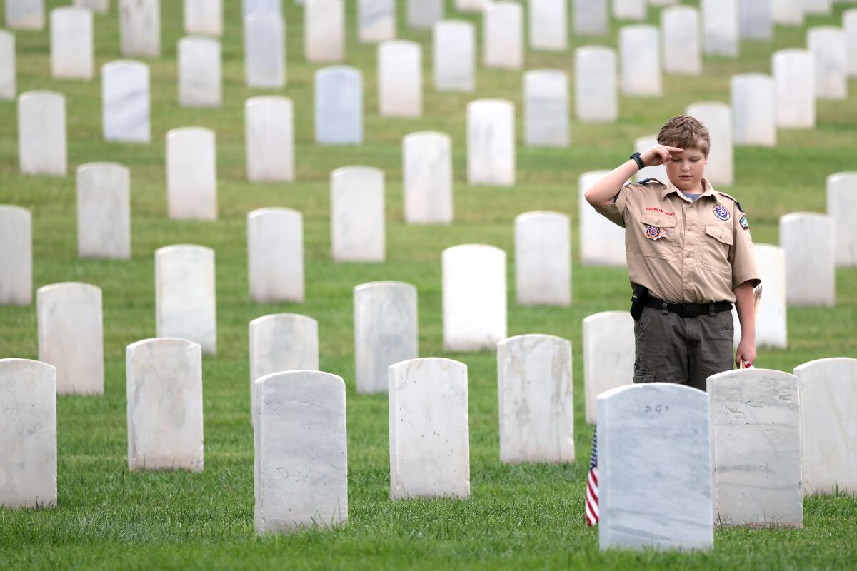 Theodore Bullock, 9, of Pack 41 from Rosamond salutes a grave on Saturday morning