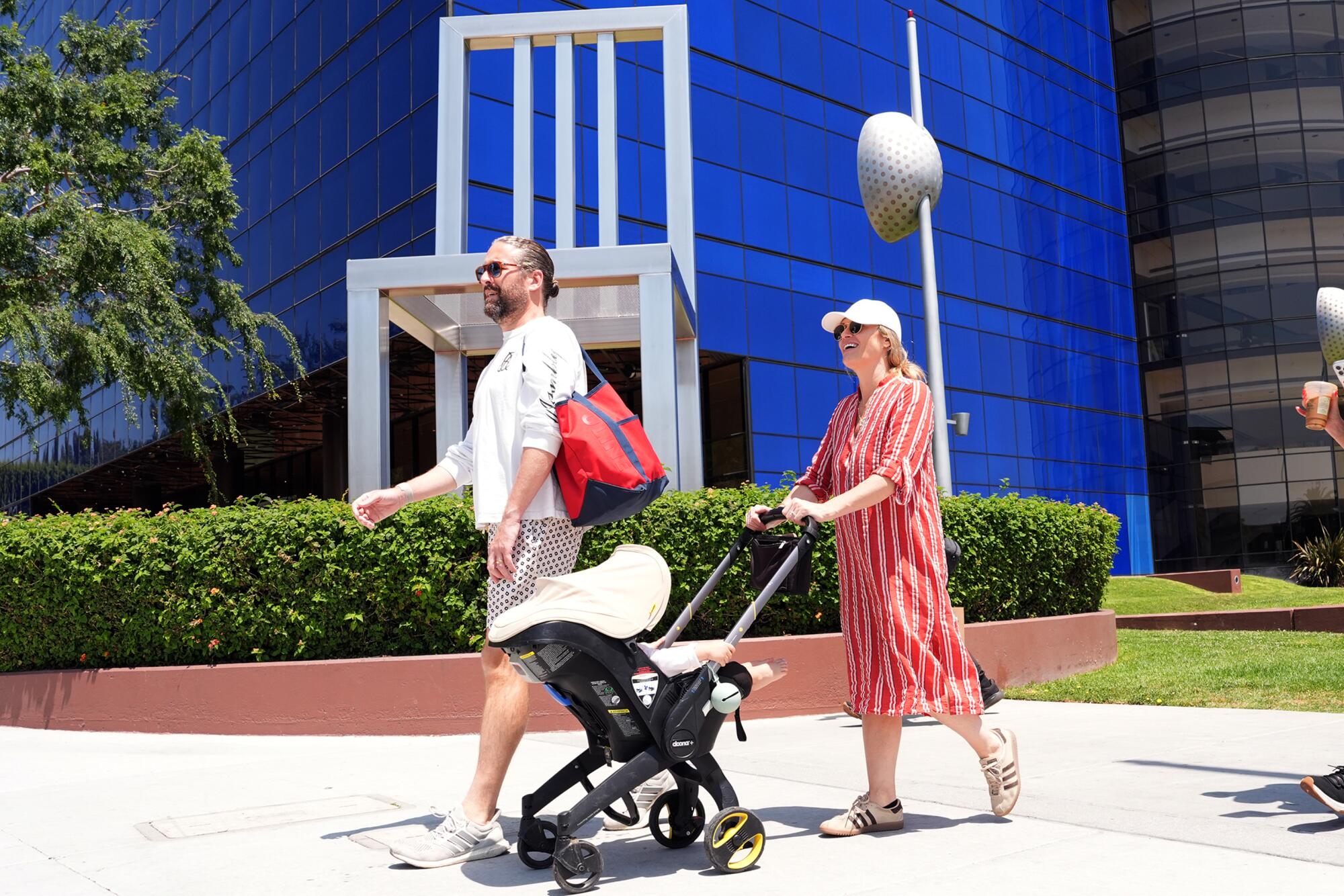 Alex Uihlein and Kimberly Beauchaine walk down Melrose Avenue with their son, Harry, 18 months old.