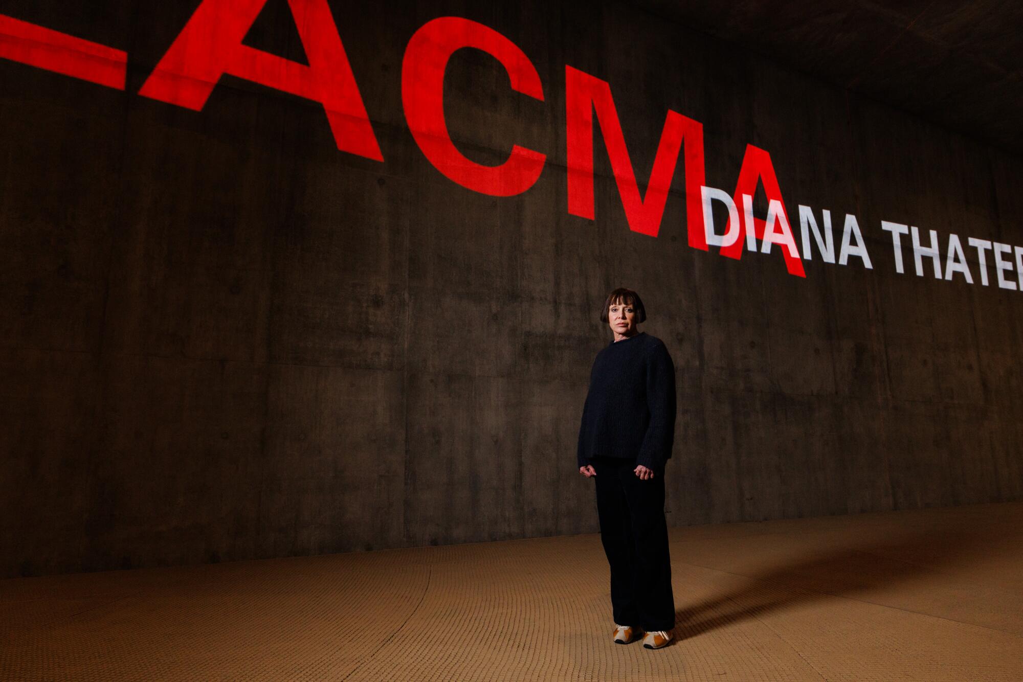 A woman in front of a video projection.