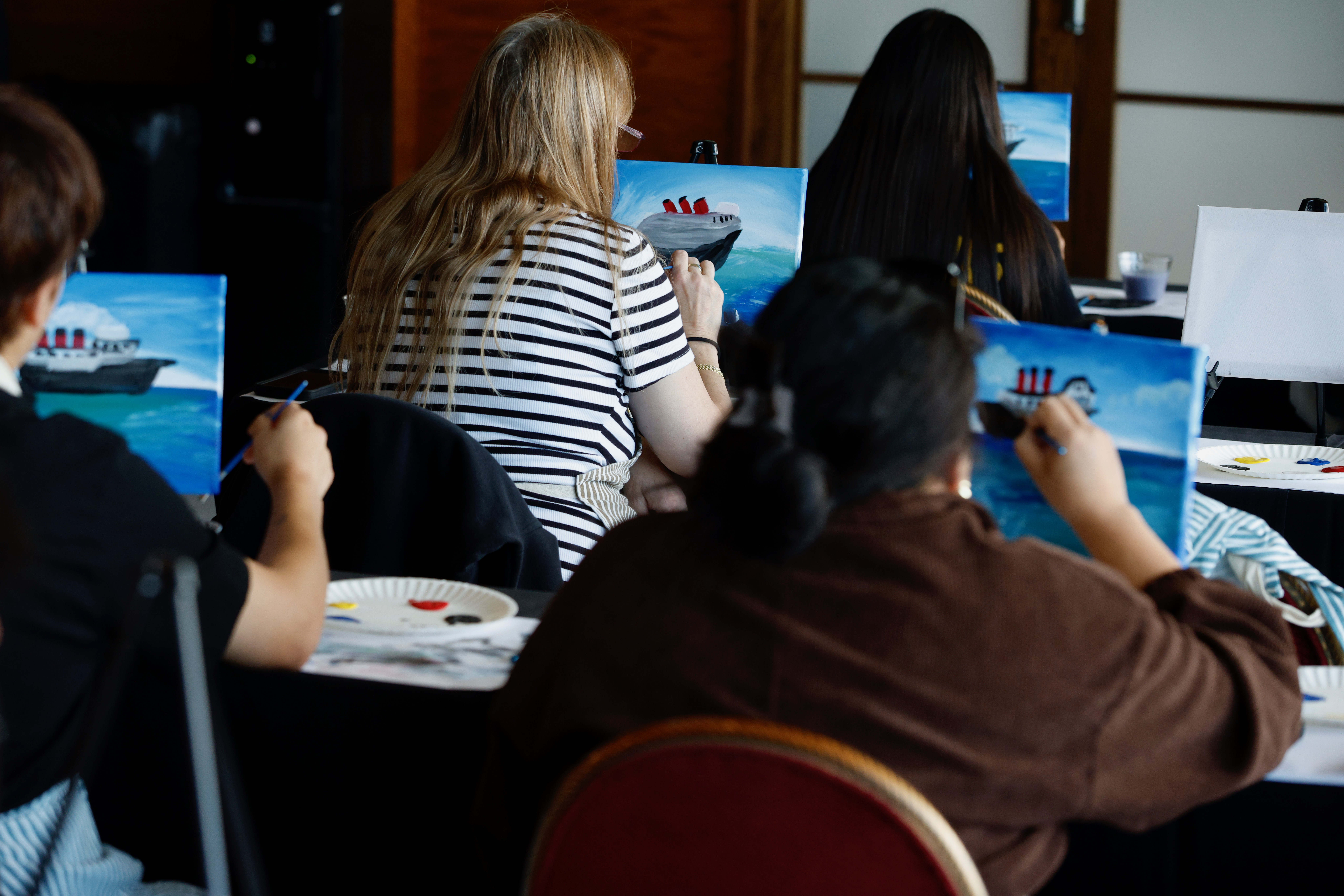 Attendees take part in a âPaint the Queenâ art class...