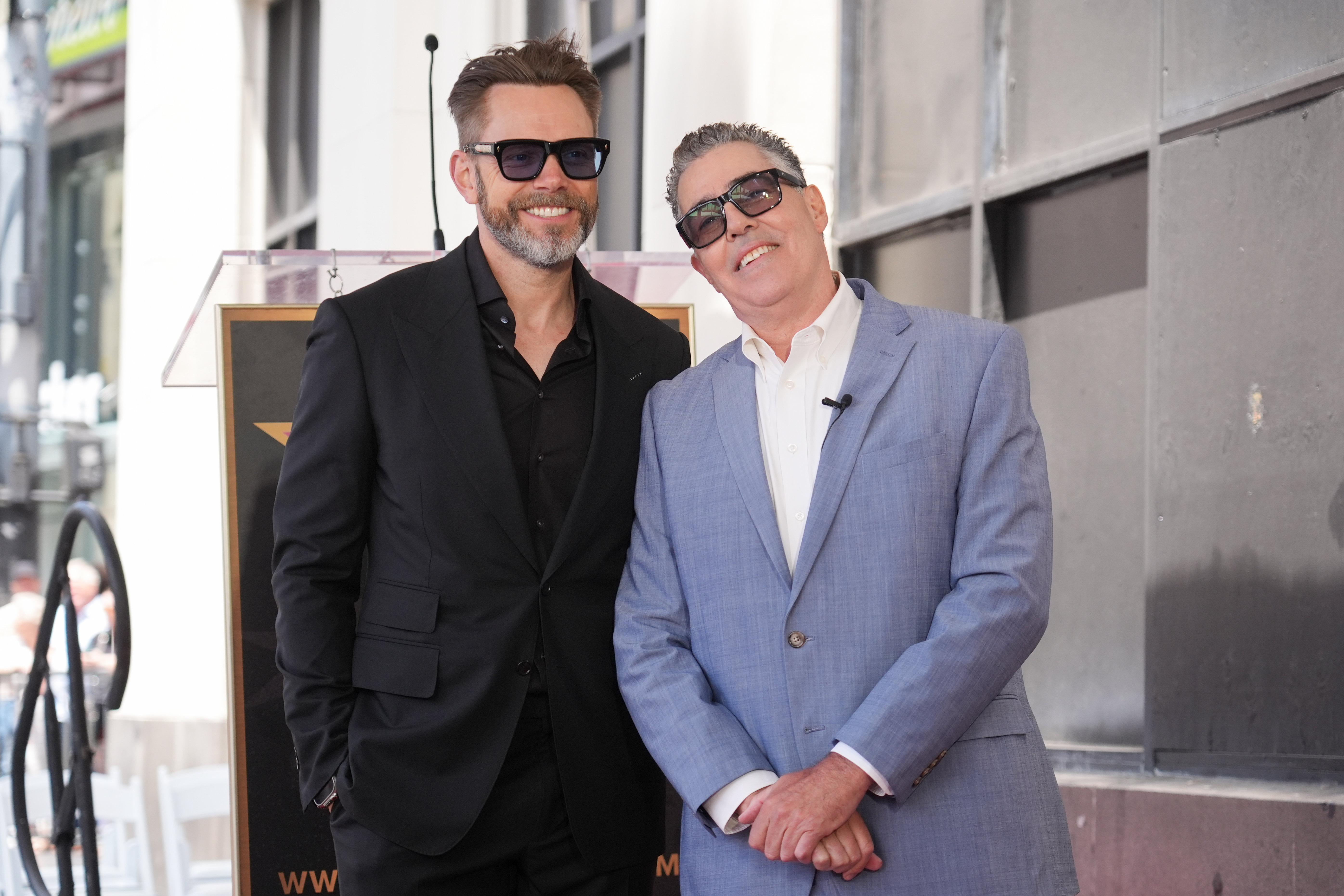 Joel McHale, left, and Adam Carolla pose with his new...