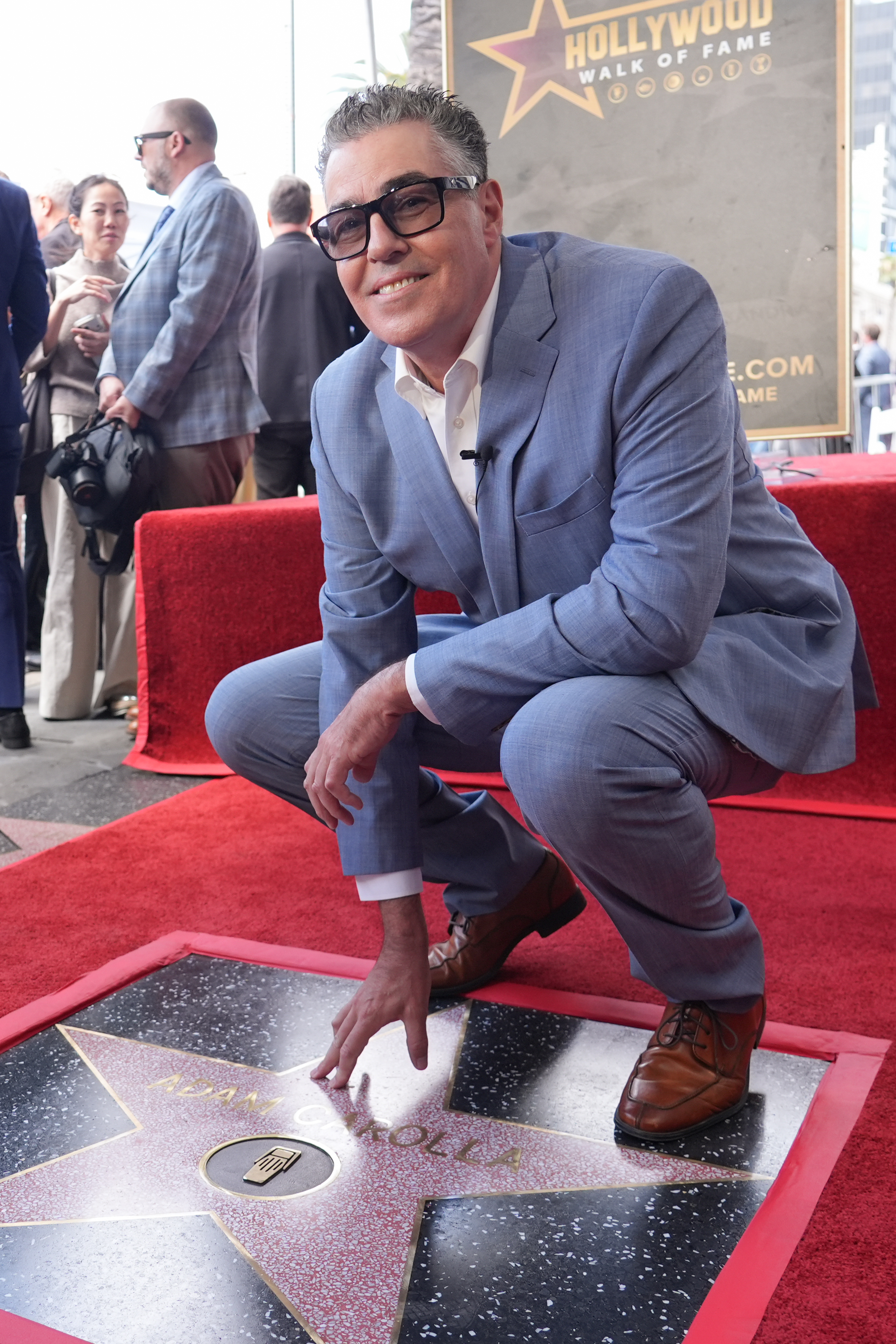 Adam Carolla poses with his new star during a ceremony...
