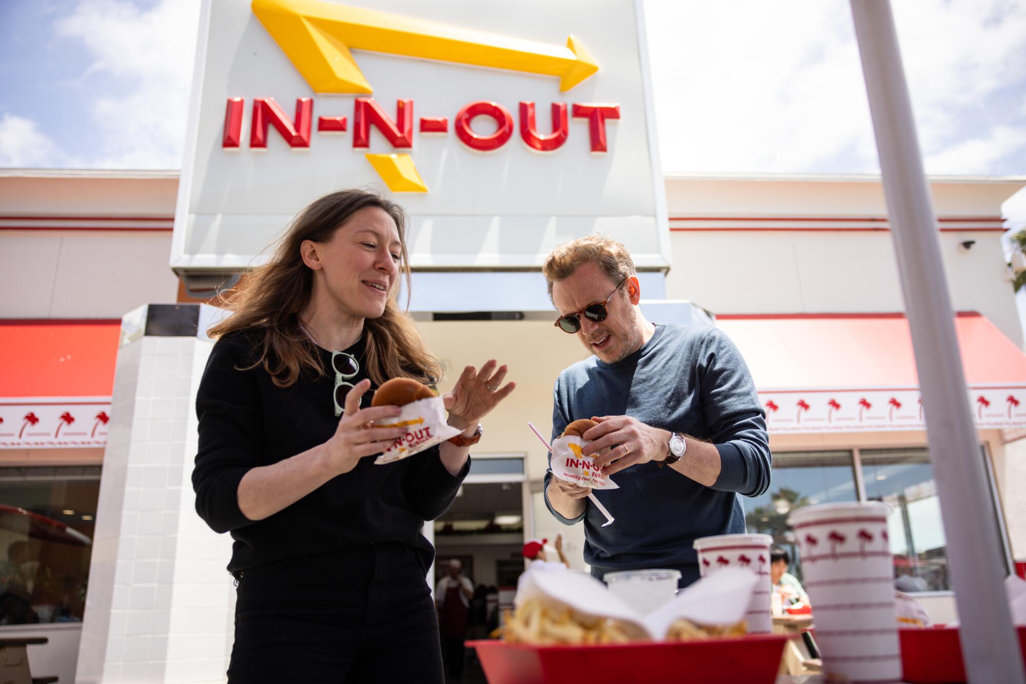 Meghan Umber, left, and Daniel Harding eat outside an In-N-Out Burger restaurant.