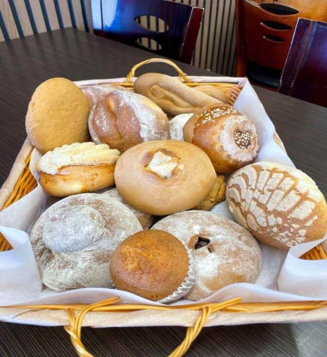 A basket of baked bread sitting on a table.