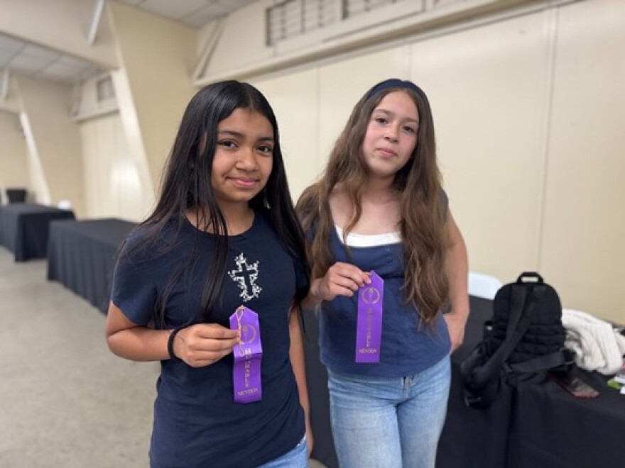 Brenda Portillo and Briana Rivas show off their honorable mention ribbons at the Young Author’s Faire.