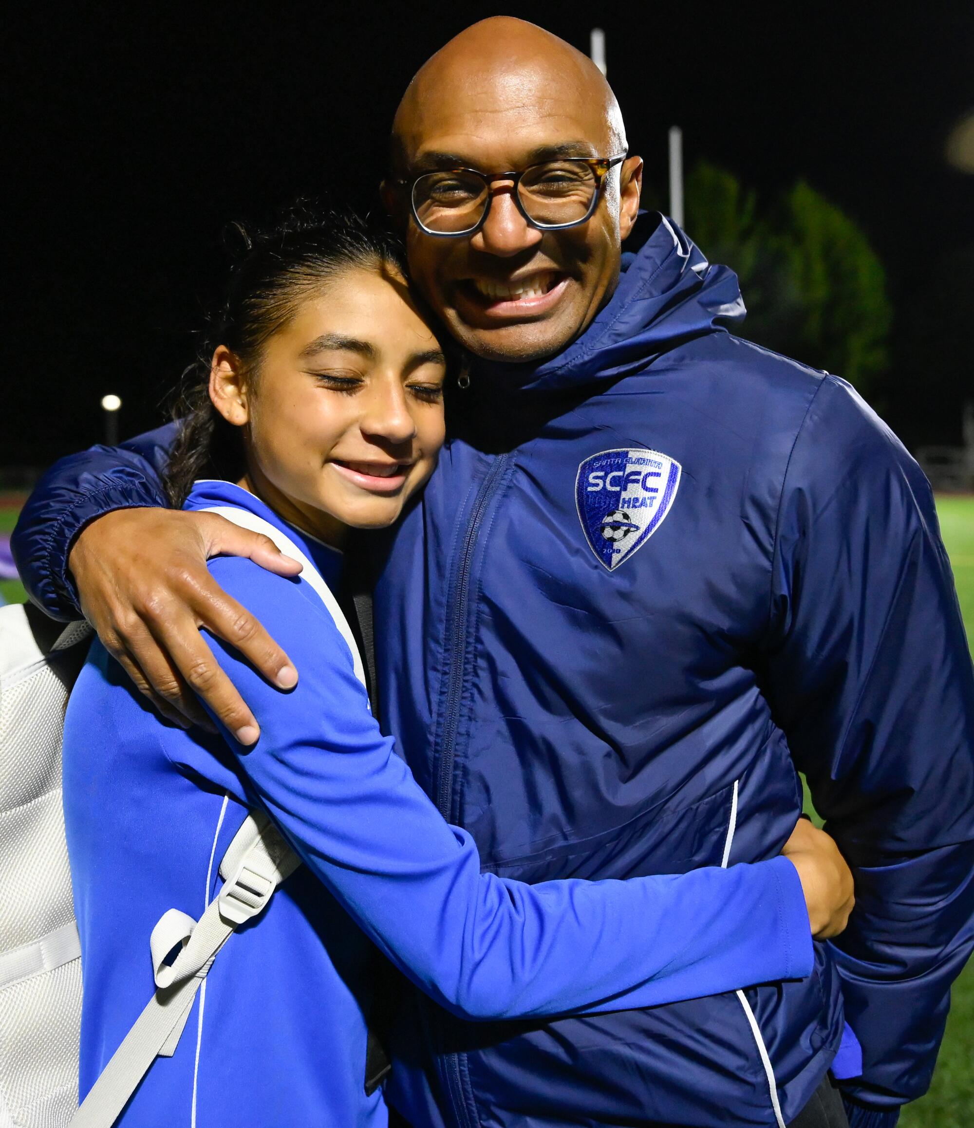 Zoe Thompson hugs her father Mario Thompson after practice.