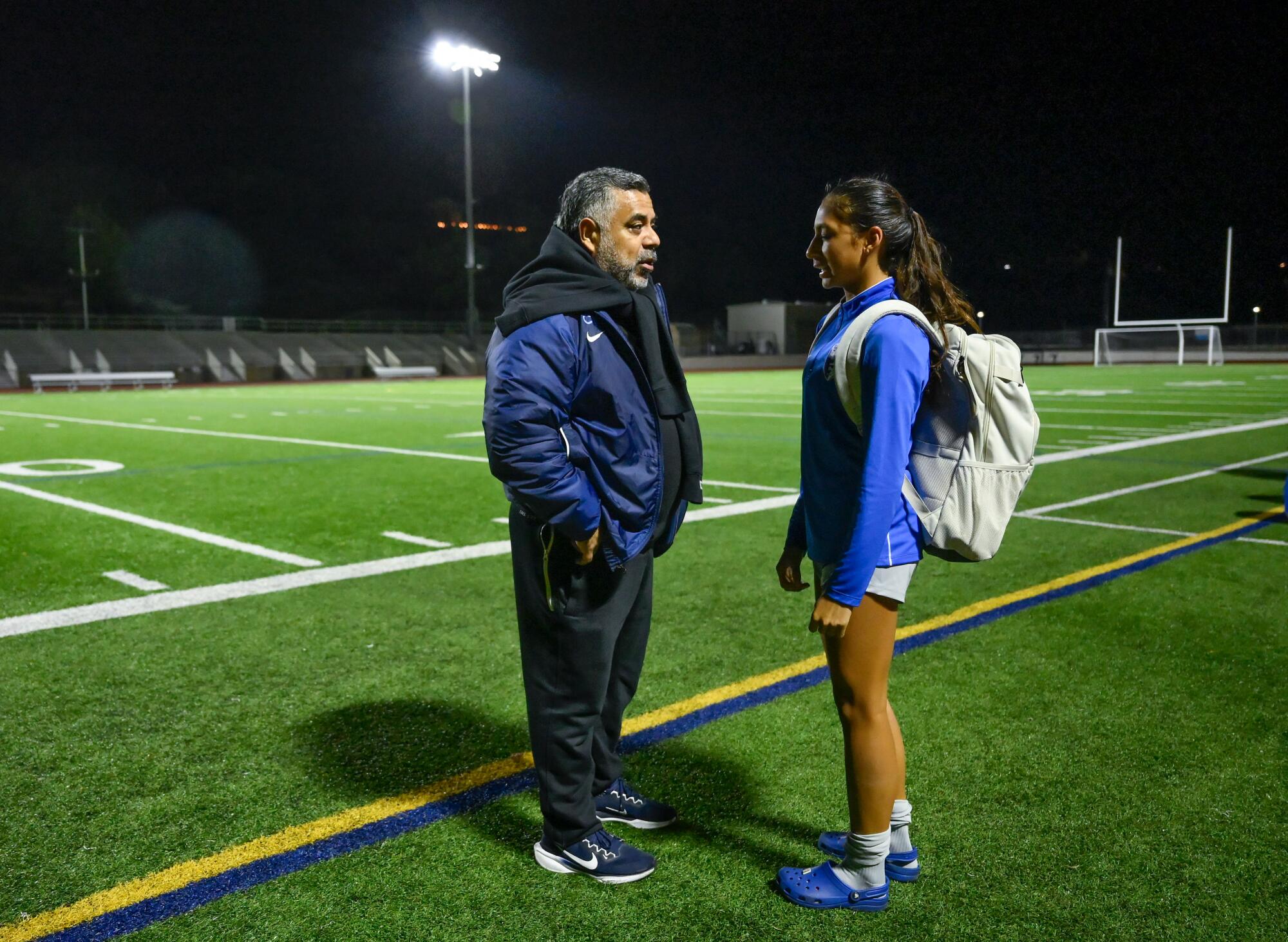 Team owner Carlos Marroquin talks to Zoe Thompson after a training session.