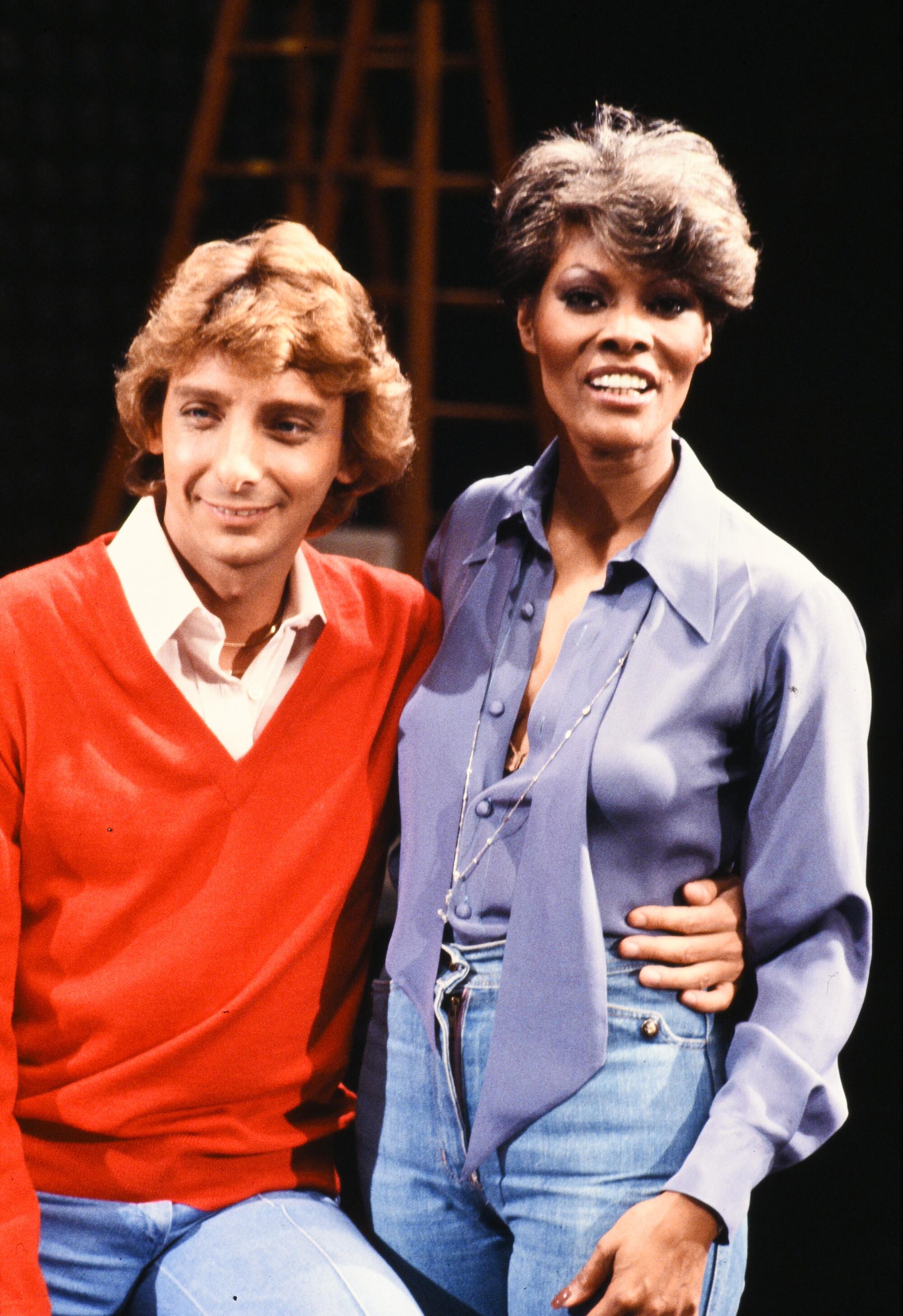 Barry Manilow holds Dionne Warwick's waist. 
