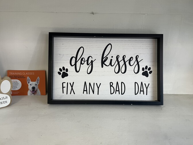 A framed sign reads "dog kisses fix any bad day"