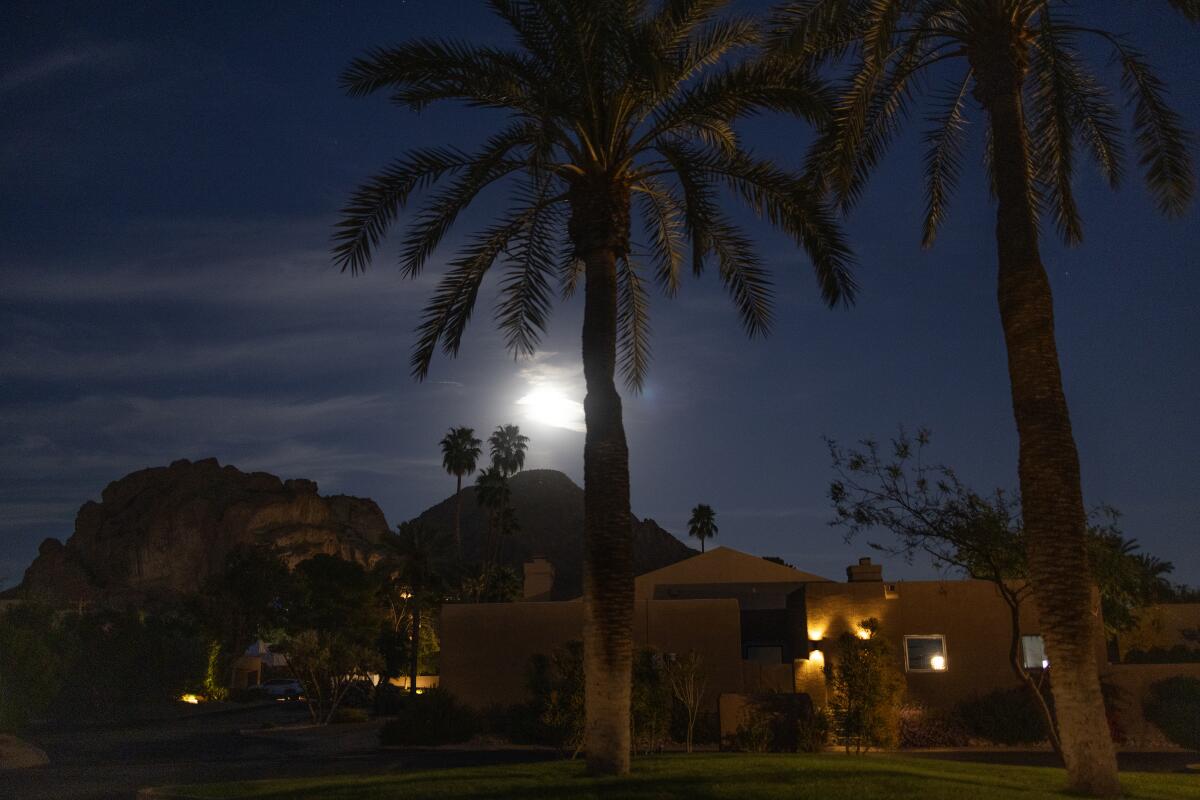 The moon shines over a housing community on the edge of Camelback Mountain in Phoenix on March 2.