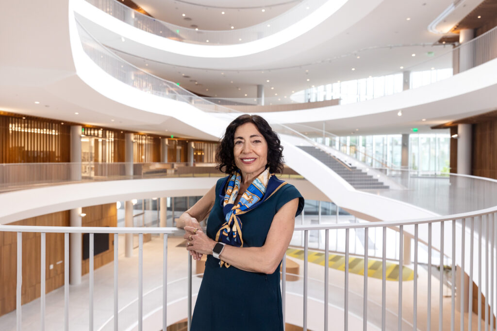 Dean Jennifer Chayes leans against the staircase railing inside the Barbara and Gerson Bakar Gateway, home of the UC Berkeley College of Computing, Data Science, and Society.