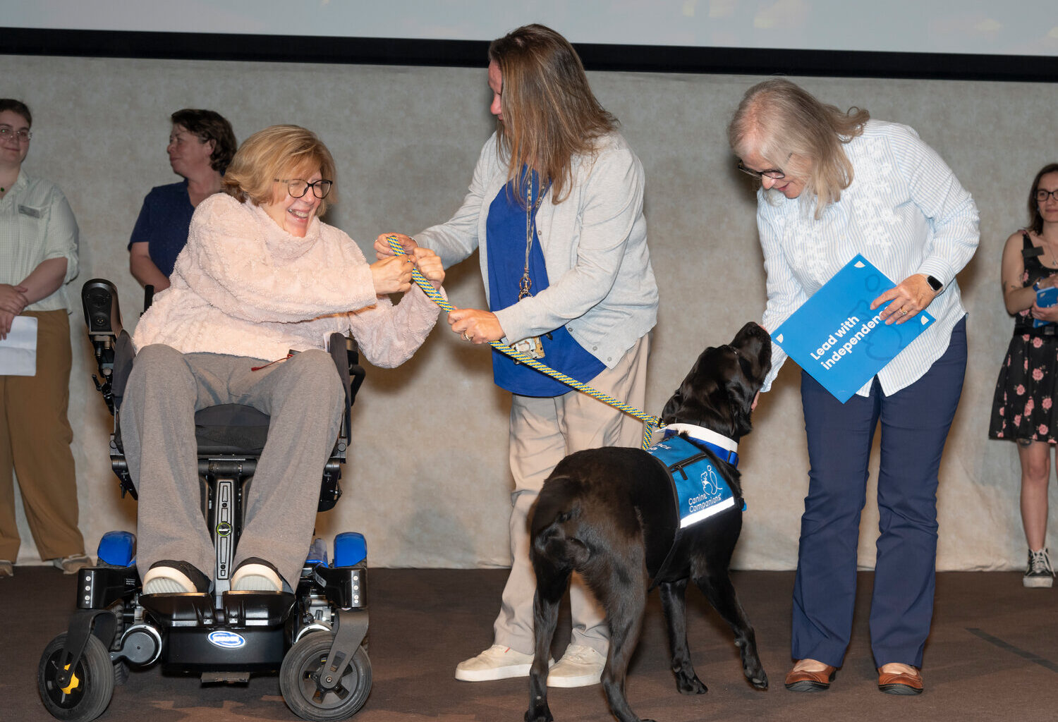 Tiffany Gordon, center, the volunteer puppy raiser from northern Virginia who trained Lucas, passed the service dog