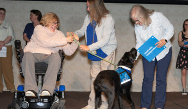 Tiffany Gordon, center, the volunteer puppy raiser from northern Virginia who trained Lucas, passed the service dog