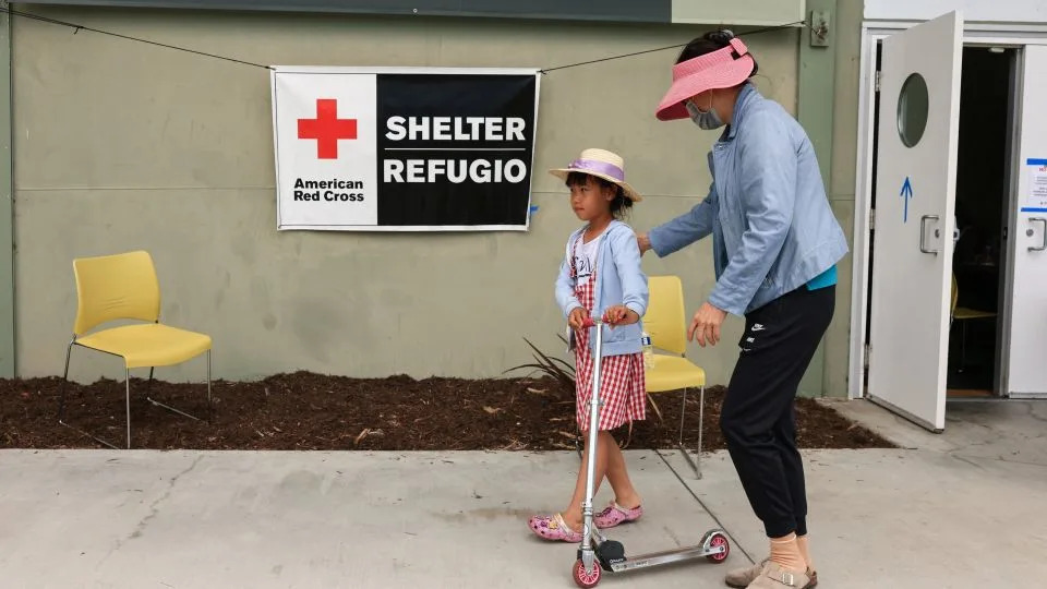 A woman and a child walk outside a shelter Saturday in Fountain Valley, California. - David Swanson/Reuters
