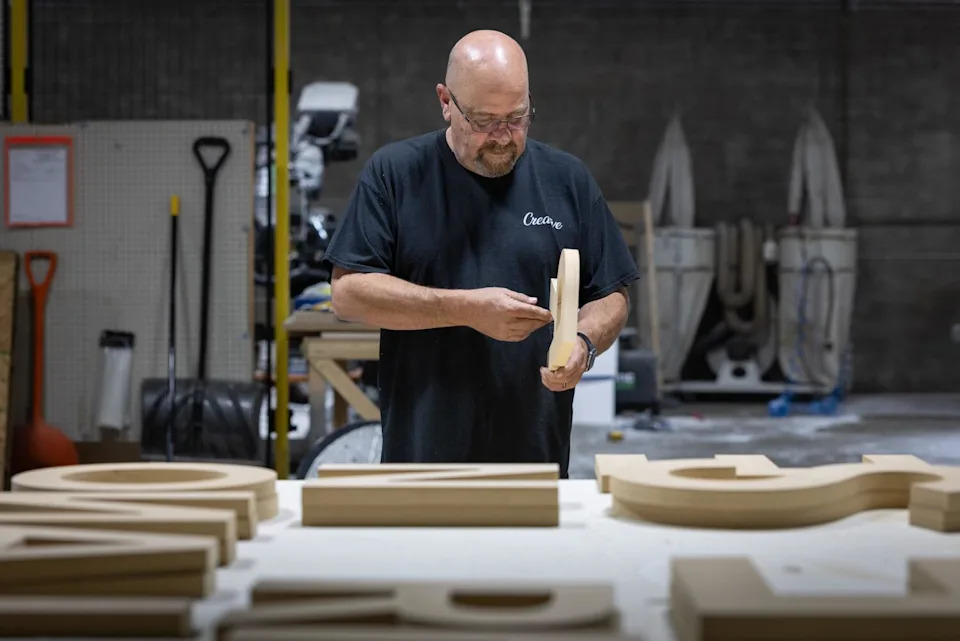 A man examines woodwork in a shop