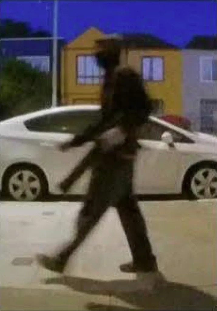 The suspect could be seen on the sidewalk holding a long gun.