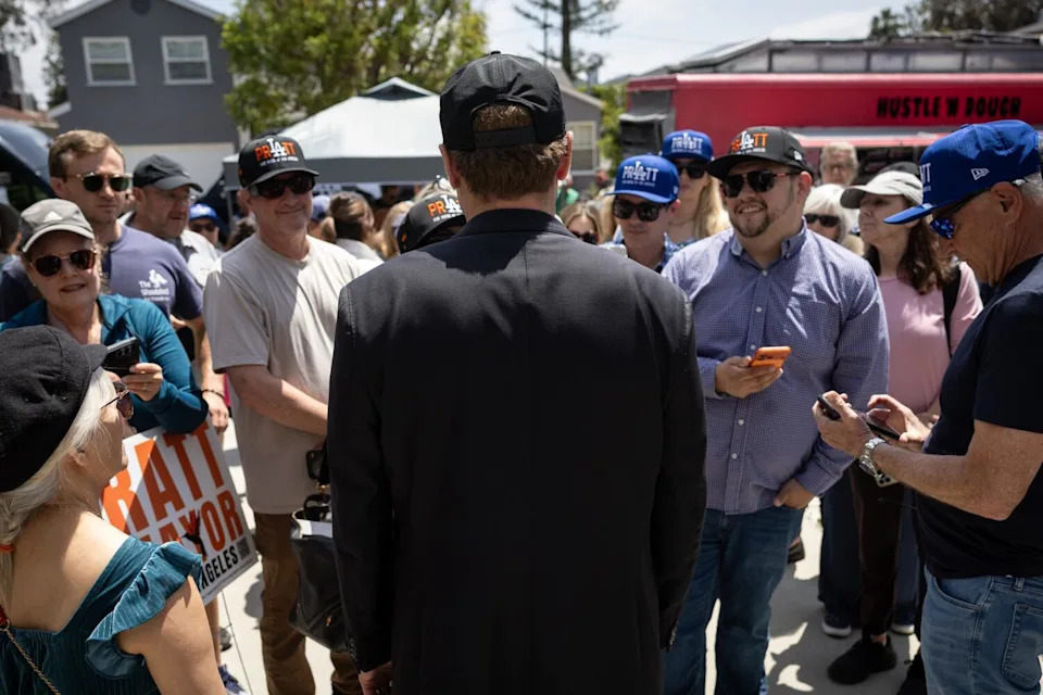 Mayoral candidate Spencer Pratt, back to the camera, speaks with supporters