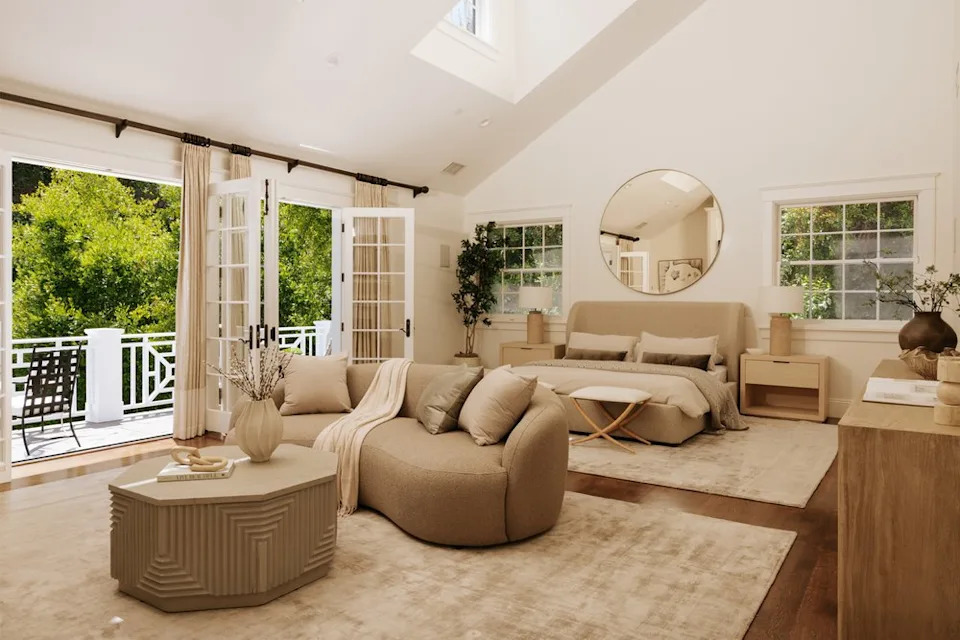 Upstairs, a stunning primary suite takes center stage, offering enough room for a private indoor seating area, while an enormous private balcony overlooking the lush backyard serves as the ideal space for a morning coffee. <span class="image-credit">(Christian Cruzio Studios)</span>