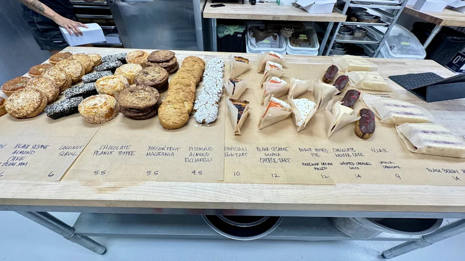 A selection of pastries on a prep table with names and prices from Grand Opening in Oakland.