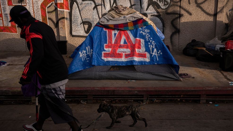 FILE - A man walks past a homeless encampment in downtown Los Angeles, Oct. 25, 2023. (AP Photo/Jae C. Hong, File)