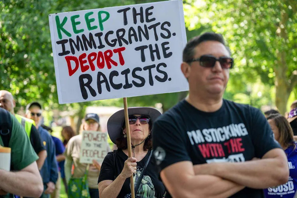 Maurya Perazzo of Sacramento holds a sign at Southside Park in Sacramento as she joins hundreds participating in the “A Day Without Immigrants” 20th anniversary march on Friday. Protesters demonstrated against ICE outside the John E. Moss Federal Building on Capitol Mall.
