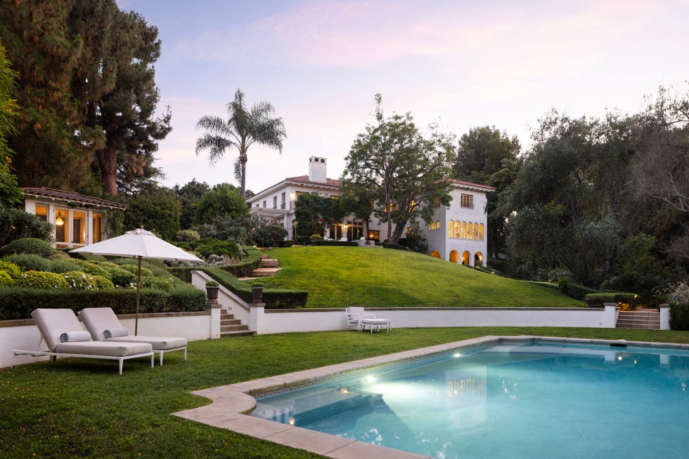 Outdoor view of a luxurious estate with pool and landscaped garden. Outdoor view of a luxurious estate with pool and landscaped garden.